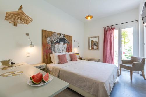a bedroom with a bed and a table with a plate of fruit at Ammos Tolo in Tolo