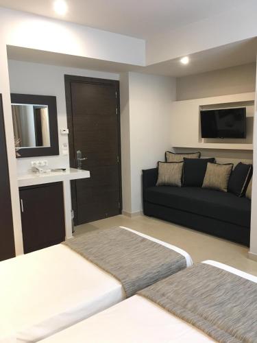 a living room with a black couch and a sink at Maison Hotel in Halkidona