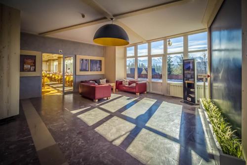 a living room with two red couches and windows at Rysy in Bukowina Tatrzańska