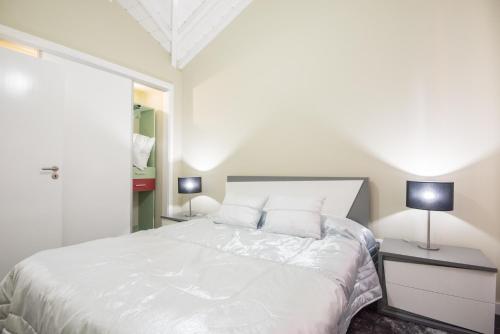 1 dormitorio con 1 cama blanca grande y 2 lámparas en Casa Céu D'Abraão en Piedade