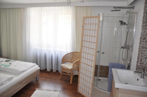 a bathroom with a shower and a bed and a sink at Gästehaus Wachau in Leiben