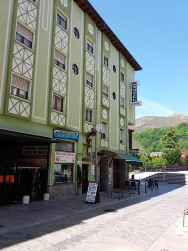 a green building with a sign in front of it at Pension Monteverde in Cangas de Onís