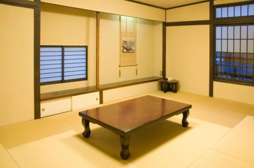 a room with a table and two windows at Yadoya Nishijinso in Kyoto