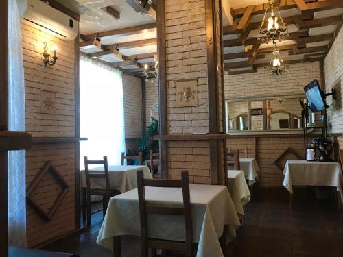 a dining room with two tables and a mirror at Paradise Hotel in Goryachiy Klyuch