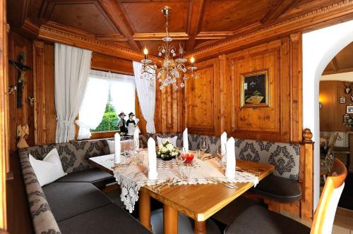 a dining room with a table and a chandelier at Hotel Viktoria & Landhaus Joggl in Mayrhofen