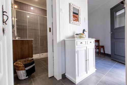 a bathroom with a shower and a white cabinet at Casa do Tanque T2 in Arouca