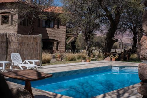 a swimming pool with chairs and a house at La Casa De La Bodega - Wine Boutique Hotel in Cafayate