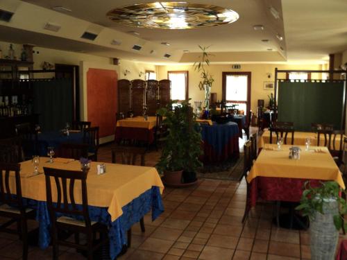 een eetkamer met 2 tafels en stoelen en een kamer met bij Albergo La Bersagliera in Noventa di Piave