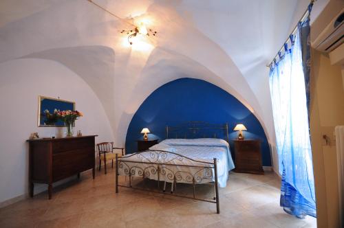 a bedroom with a bed and a blue and white ceiling at Palazzo Rocci Rooms in Gallipoli