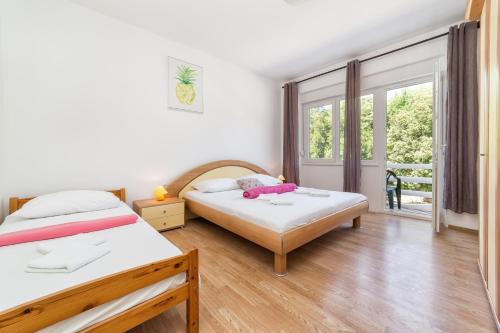 a bedroom with two beds and a large window at Sobe Mateša in Vodice