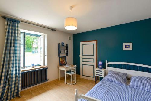 トレガンにあるAppartement Kermadoué 1の青いベッドルーム(ベッド1台、窓付)