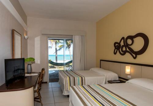 um quarto de hotel com duas camas e vista para o oceano em Hotel Marsol Beach Resort em Natal