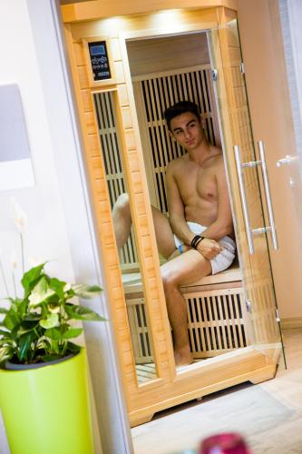 a shirtless man is sitting in a cage at B&B Da Peo in Porto San Giorgio