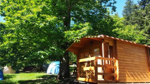 a small wooden cabin with a wooden bench at Camping Camaldoli in Camaldoli
