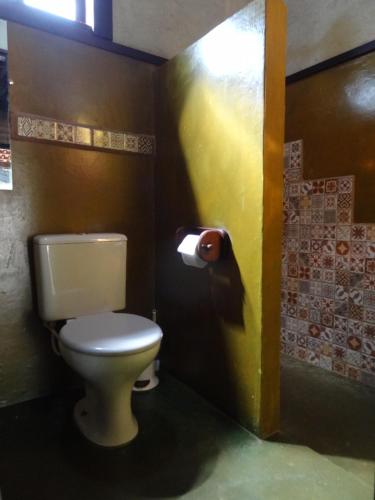 a bathroom with a toilet and a roll of toilet paper at Chalé Chapada dos Veadeiros in Cavalcante