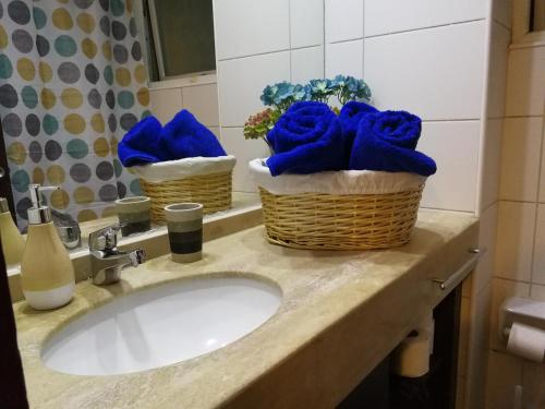 a bathroom sink with blue towels in baskets on it at Apartamentos Santiago Centro R&M in Santiago