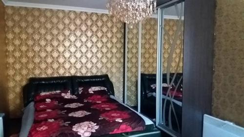 a bedroom with a bed and a chandelier at Аркадия Флэт in Odesa