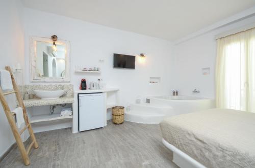 a white bathroom with a bed and a tub and a sink at Blue Sky Summer in Naxos Chora