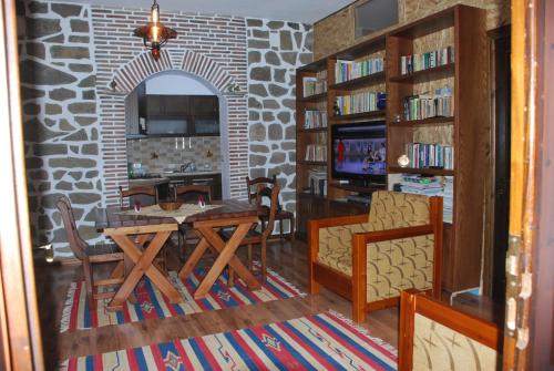 a dining room with a table and chairs and a stone wall at bed & breakfast Local Living Edi in Berat