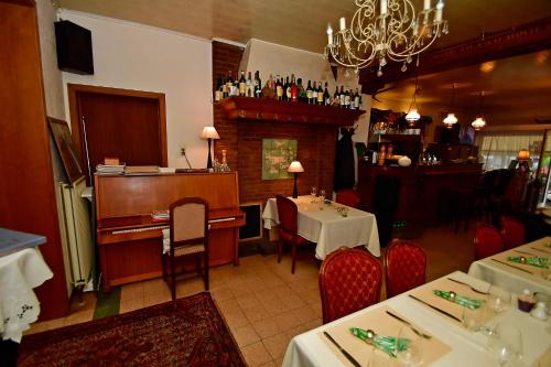 een restaurant met een piano en een tafel en stoelen bij Hotel 'T Hert in Genk