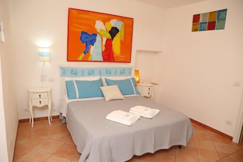 a bedroom with a bed with a painting on the wall at Il Tramonto in Castelsardo
