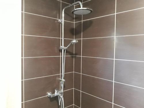 a shower with a brown tile wall at The Santo George Beach Resort in Amoudara Herakliou