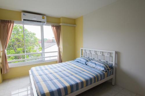 a bedroom with a bed and a large window at Bann In Suan in Ban Lat Tanot
