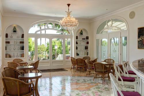 a dining room with tables and chairs and a chandelier at Grand Hotel Royal in Sorrento