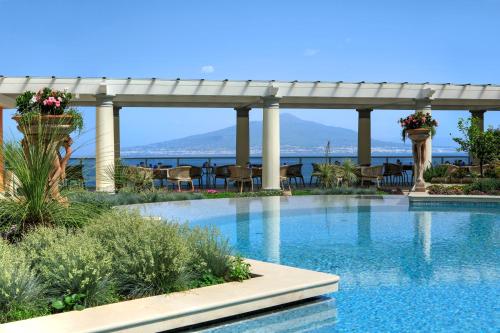 een zwembad van het resort met uitzicht op het water bij Grand Hotel Royal in Sorrento