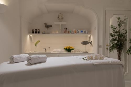 a white bedroom with a bed with towels on it at Grand Hotel Royal in Sorrento