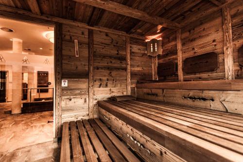 drewniana ławka w pokoju z drewnianymi ścianami w obiekcie Aktivhotel Tuxerhof w mieście Zell am Ziller