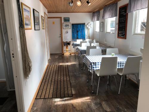 a dining room with tables and white chairs at Kajsa krabbat Vandrarhem in Kungshamn
