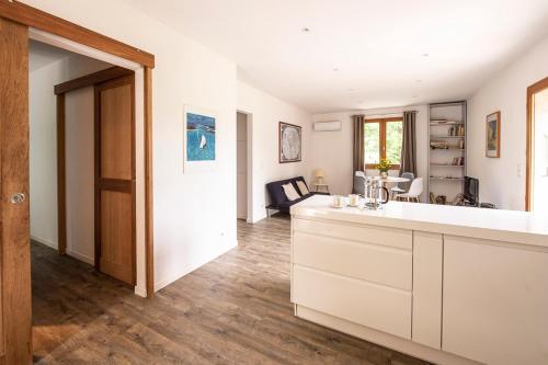 eine Küche mit einer weißen Theke und ein Wohnzimmer in der Unterkunft Les jardins de Foata in Barbaggio