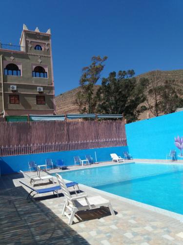 a swimming pool with chairs and a building at Auberge Restaurant le Safran in Taliouine