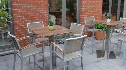 a row of tables and chairs on a patio at B&B Coup de Coeur in Moorslede