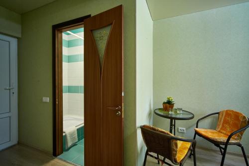 a room with a table and a door leading to a bathroom at Domashniy in Kamianets-Podilskyi