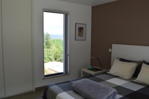 un dormitorio con una cama y una ventana en Guesthouse Bem Vindo, en Cela Velha