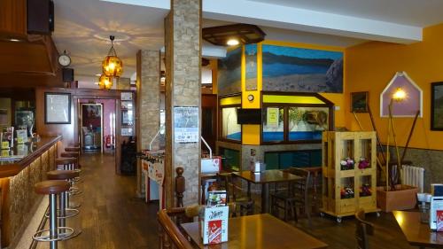 a restaurant with a bar and some tables and chairs at Hotel A Marisqueira I Aeropuerto A Coruña in Oleiros