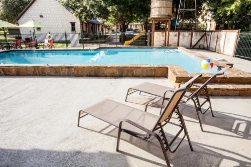 a pair of chairs sitting in front of a swimming pool at Gruene Cottages in New Braunfels