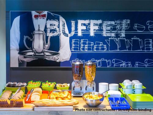 a table with food and a picture of a chef at Ibis Budget Saint Malo Centre in Saint Malo