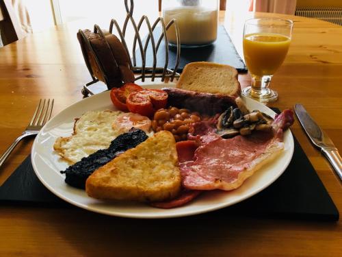 a plate of breakfast food with eggs bacon beans and toast at Ashdale Guesthouse in Matlock