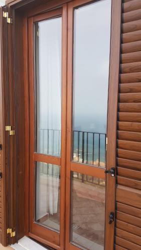 a sliding glass door with a view of the ocean at Residenza Porta di Mare in Castellabate