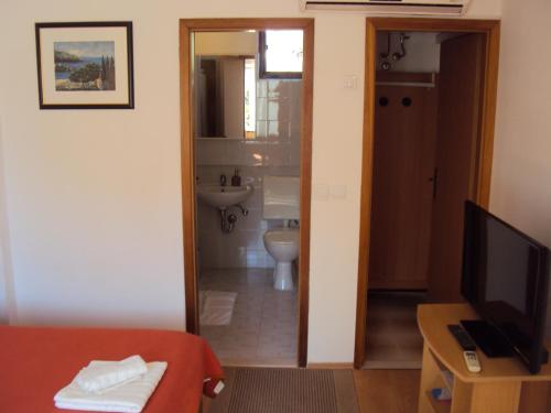 bagno con servizi igienici e TV in camera di Apartment Lemon a Dubrovnik