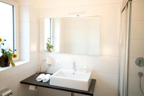 a white bathroom with a sink and a mirror at Pension Sattlerenglhof in Laces