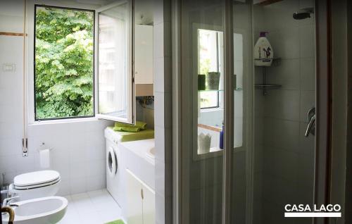 a bathroom with a toilet and a sink and a window at CasaLago di Erika e Antonella in Pisogne