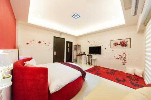 a bedroom with a red bed and a red couch at 醇境民宿市區車庫停車場 in Hualien City