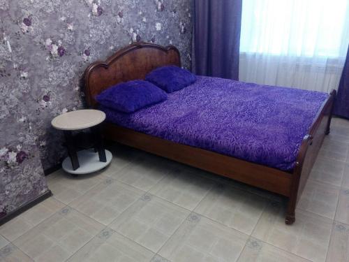 ノヴォクズネツクにあるКутузова 43 2 подъездの紫色のベッド(紫色の掛け布団、テーブル付)