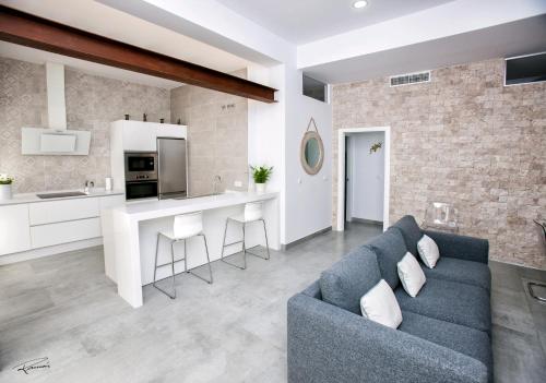 a living room and kitchen with a blue couch at La Pandorga in Sanlúcar de Barrameda