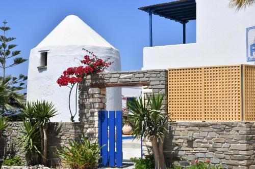 a building with a blue door and flowers on it at Fotilia Hotel in Naousa