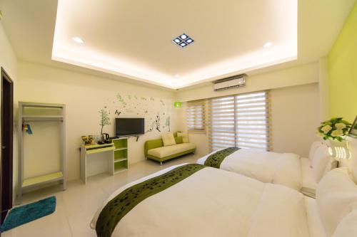 1 dormitorio con 1 cama blanca grande y TV en Pure B&B, en Hualien City